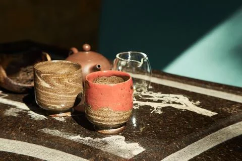Chinese tea ceremony. Brown ceramic pot, tea pair, cup in hand, brown cup Stock Photos