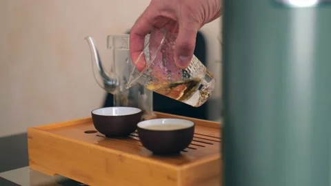 Chinese tea ceremony. a man's hand pours brewed white tea into a bowl Stock Footage 220342198