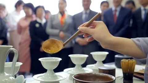 Chinese tea ceremony performance. Pours tea into a cup. People on the background Vidéo 114795412