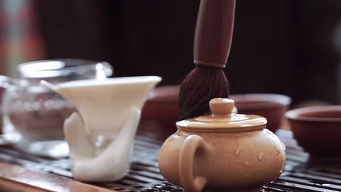 Chinese tea ceremony, using a tea brush a small kettle is wiped from the hot Stock Footage 122360061