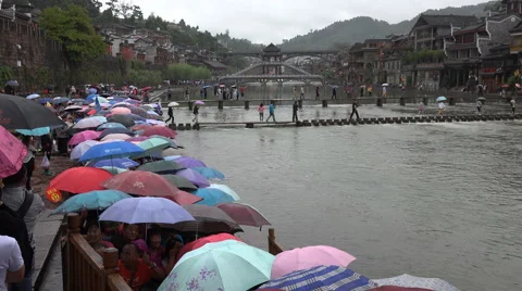 Chinese tourists queue for a boat ride in the rain in Fenghuang Stock Footage 60396026