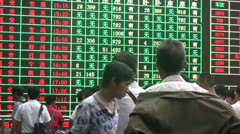 Chinese train schedule board, passenger looks overwhelmed by information Stockbeeldmateriaal 7750762