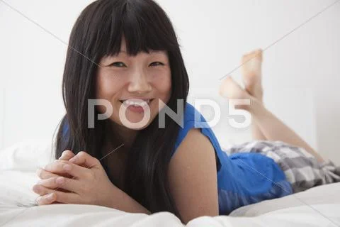 Chinese woman laying on bed Stock Photos