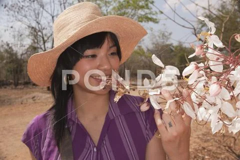 Chinese woman looking at flowering tree Stock Photos