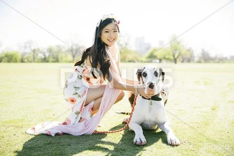Chinese Woman Petting Dog In Field