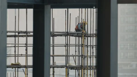 Chinese Worker framed by construction site Stock Footage 224351694