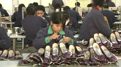 Chinese workers in China Donguan Shoe Factory - workers with shoes pile Stock Footage