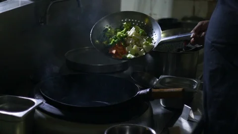 Chinesse food. Working chef preparing chinese food, Food frying in wok pan. Video stock 117782535