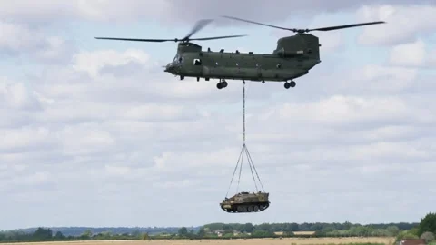 Chinook hovering while lifting an armoured personnel carrier in slow motion Stock-Footage 276337025