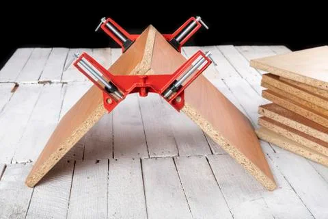 Chipboard in an angular carpentry clamp. Fixing the material for machining. Foto stock