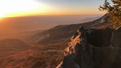 Chipmunk perched on a rock wall on a high mountain ledge at golden hour Stock Footage 121984224