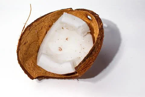 Chipped piece of coconut in the shell. Isolate. Stock Photos