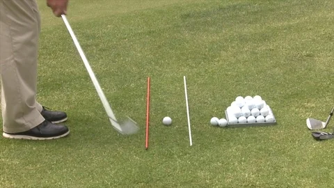 Chipping onto a golf practice green using aiming rods Stock Footage 80509427