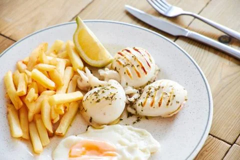 Chips and grilled cuttlefish Stock Photos