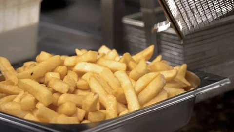 Chips being emptied from deep fat fryer in commercial kitchen Stock Footage 101341104