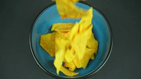 Chips Falling Onto A Blue Plate In Slow Motion Stock Footage 243433965