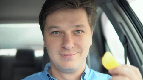 Chips or an apple. A man is eating an apple in a car. Stock Footage 81826853