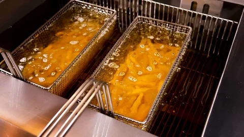 Chips Potato fries start boiling in fresh oil Stock Footage 94274750