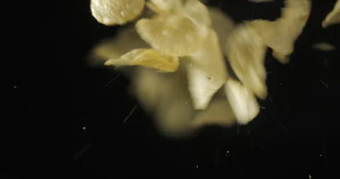 Chips of potatoes falling from below, slowmotion low angle 4K pro res Stock Footage 275897342