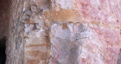 Chips of rock erosion along edge of colorful rough pink, white and tan rock 4k Stock Footage 315894067
