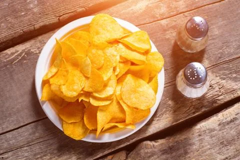 Chips with salt and pepperbox. Stock Photos