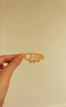 Chips in the shape of a dinosaur on a light background. Stock Photos