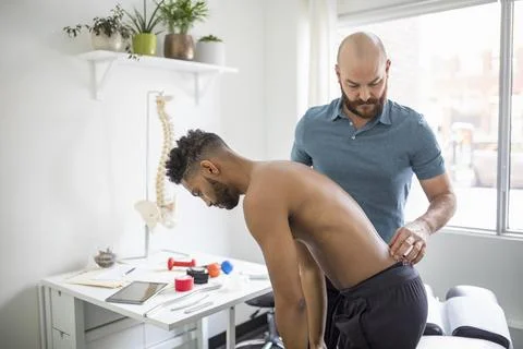 Chiropractor helping client with spinal adjustment Stock Photos