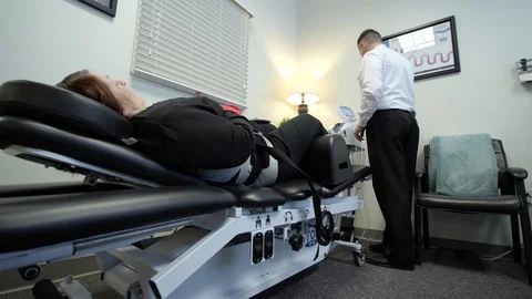 Chiropractor setting up chiropractic table for a patient Stock Footage 126600431