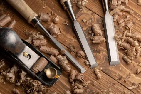 Chisel and small block plane with wood shavings Stock Photos