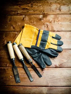 Chisel with construction gloves on the table. Stock Photos