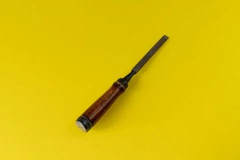 Chisel with a wooden handle on a colored background Stock Photos