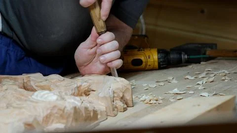 Chisel work highlighting craftsmanship details, Refining carved surface with Stock Photos