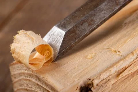 Chisel work in wood and raw wood shavings. Tools and accessories in a carpent Stock Photos