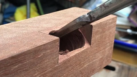 Chiseling a deep rectangular mortise into a wooden beam Stockbeeldmateriaal 317598886