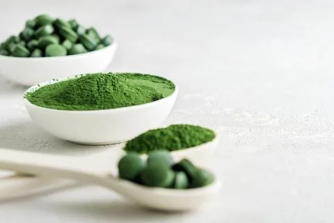 Chlorella or spirulina in the form of tablets and powder on a gray concrete b 写真素材