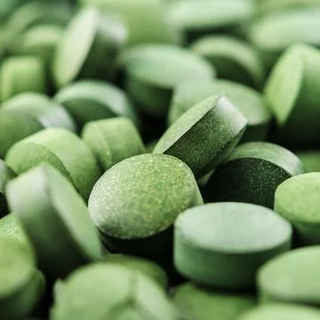 Chlorella or spirulina tablets close up. Texture of tablets spirulina or chlo Stock Photos