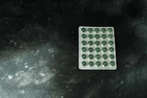 Chlorella or spirulina tablets on dark background Foto stock