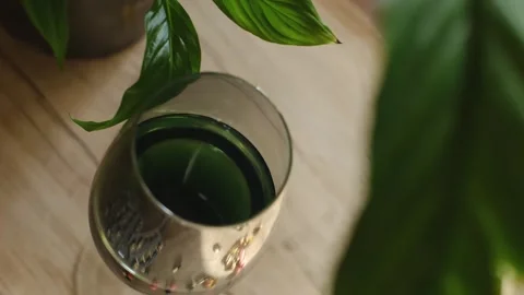 Chlorophyll bottle stands on the table surrounded by lush green plants, promotin Video stock 267229280