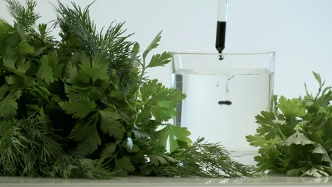 Chlorophyll extract is poured in pure water in glass Stock Footage 156759082