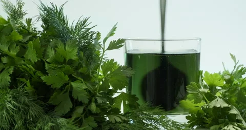 Chlorophyll extract is poured in pure water in glass Stock Footage 156855342