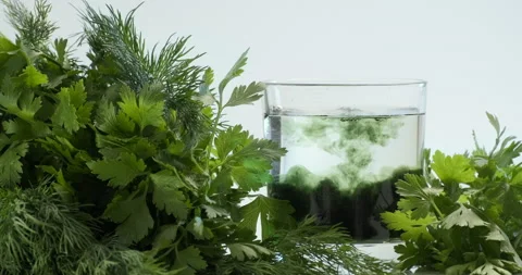 Chlorophyll extract is poured in pure water in glass against Stock Footage 156972985