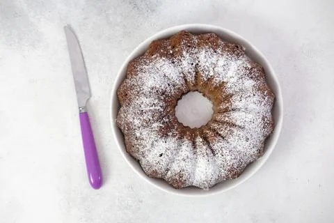 Chockolate cake with purple knife on gray background. Foto stock