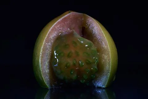 Choco tomato cut open on black background showing pulp and locules in detail Fotos Stock
