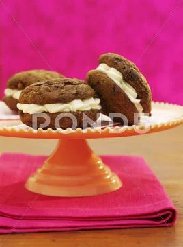 Chocolate and ginger whoopie pies filled with cream Stock Photos