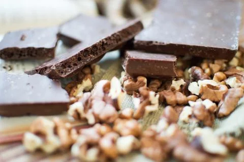 Chocolate and nuts lying on a table. Фото