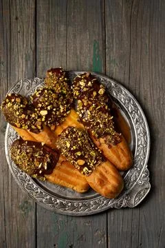 Chocolate and pistachio eclair on a plate Stock Photos