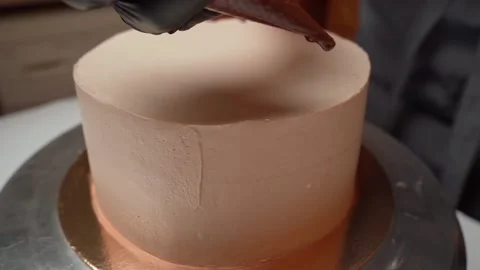 Chocolate is applied to the edge of the cake, drops flow down the board of the Stock Footage 155450761