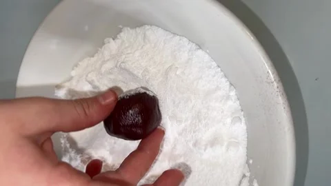 Chocolate ball is placed in flour Stock Footage 228725983