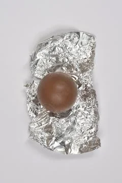 Chocolate ball on silver foil wrapper. Stock Photos