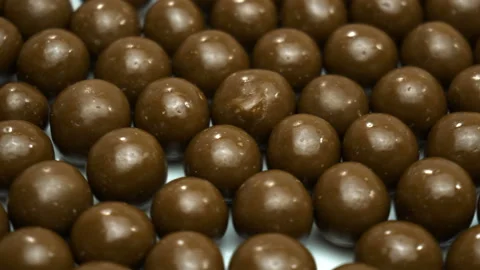 Chocolate balls are rotating on the plate. Camera zoom Video stock 86993151